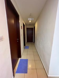 um corredor com tapetes azuis no chão e uma porta em Robin Beach Hostel JBR em Dubai