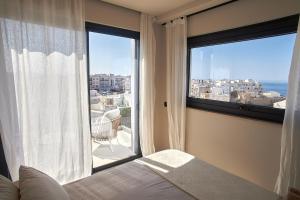 a bedroom with a bed and a large window at White Coast in Polignano a Mare +21 photos