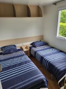 two beds sitting in a room with a window at Camping Ixtila mobilhome in Larrau