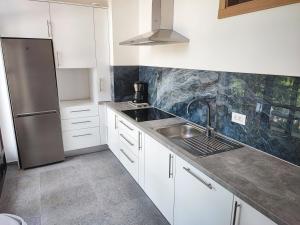 a kitchen with a sink and a stainless steel refrigerator at Apartment Ivan-Experience Elite in Ljubuški
