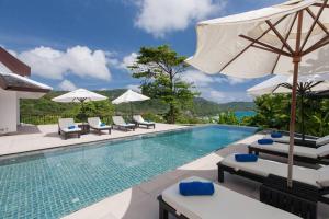 a swimming pool with chairs and umbrellas at Katamanda - Villa Katamalee Private Pool near Kata Noi Beach in Kata Beach