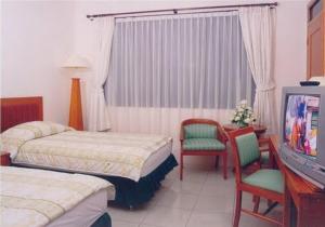 Tempat tidur dalam kamar di Griya Sentana Hotel
