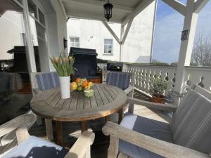 a wooden table with a bowl of fruit on a porch at Villa Seestern - Ferienhaus mit Meerblick in Sassnitz