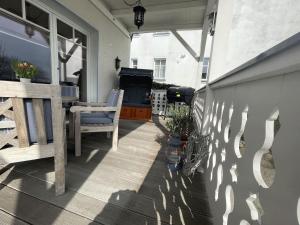 a porch with a grill and a table and chairs at Villa Seestern - Ferienhaus mit Meerblick in Sassnitz