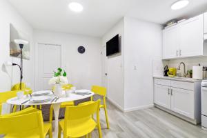 a kitchen and dining room with a table and yellow chairs at Gorgeous Manhatten Gem in New York