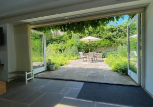 eine offene Terrasse mit einem Tisch und einem Sonnenschirm in der Unterkunft The Barn in Middleton