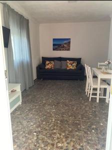 - un salon avec un canapé et une table dans l'établissement Bonita casa en Bolonia, à Bolonia