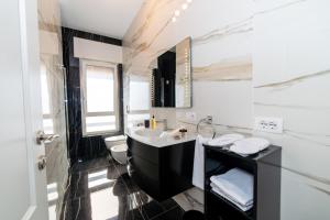 ein schwarzweißes Bad mit einem Waschbecken und einem WC in der Unterkunft Les Suites di Adi Luxury Apt in Bari