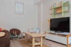 a living room with a tv and a coffee table at Bergerie du centre ville - 1 chambre, équipement bébé, wifi et draps inclus in Dieppe