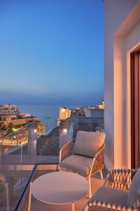 a balcony with chairs and a view of the ocean at White Coast in Polignano a Mare