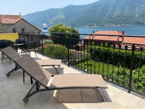 a balcony with chairs and a view of the water at 2montenegro MIMOZA Apartments in Dobrota