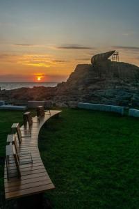 a group of benches sitting on a boardwalk at sunset at Ático nuevo en Arteixo con plaza de garaje in Arteixo