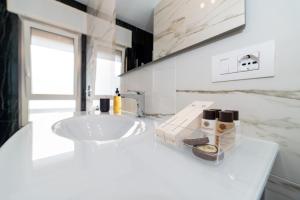 ein Badezimmer mit einem Waschbecken und einer weißen Arbeitsplatte in der Unterkunft Les Suites di Adi Luxury Apt in Bari