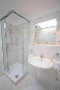 a bathroom with a glass shower and a sink at Hotel Imperial Rügen in Binz