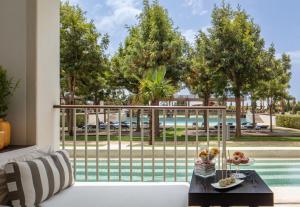 un soggiorno con divano bianco e vista sulla piscina di Anantara Vilamoura Family Friendly a Vilamoura