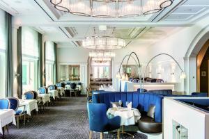 ビンツにあるA-ROSA Kurhaus Binzのダイニングルーム(青い椅子、テーブル付)