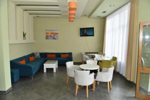 a living room with a couch and a table and chairs at Vila Namiku in Durrës