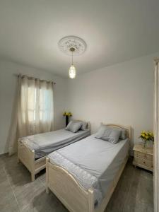 two twin beds in a bedroom with aermottermottermottermott at Entire villa two floors sea view-Chatt Mariem in Sousse