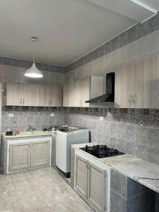 a kitchen with a stove and a white refrigerator at Entire villa two floors sea view-Chatt Mariem in Sousse