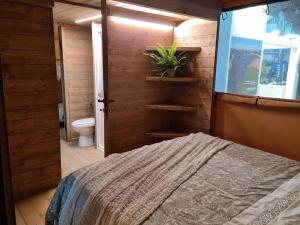 a bedroom with a bed and a bathroom with a toilet at Glamping Debbiare in Riparbella