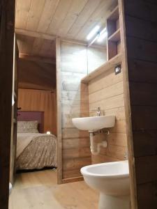 a bathroom with a sink and a toilet and a bed at Glamping Debbiare in Riparbella