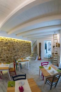 a room with tables and chairs and a stone wall at La Quercia e l'Asino in Piazza Armerina