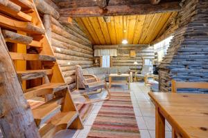 Cabaña de madera con sala de estar con sofá y mesa en Kelohonkahuoneisto Käkriäinen A, en Suomutunturi
