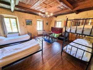 a room with three bunk beds and a table at B&B Pod Skalo in Kamnik