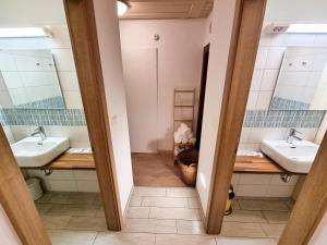 uma casa de banho com dois lavatórios e dois espelhos em B&B Pod Skalo em Kamnik