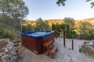 uma banheira de hidromassagem sentada num pátio com um banco em SILOM HOUSE em Sant Pere de Ribes