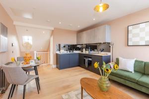 ein Wohnzimmer mit einem grünen Sofa und einem Tisch in der Unterkunft Dragon Suites Luxury Serviced Apartments at Walker Street in Edinburgh