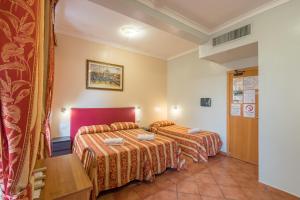 um quarto de hotel com duas camas e uma mesa em Alessandro Palace & Bar em Roma mais 37 fotografias