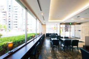 a restaurant with tables and chairs and large windows at Villa Fontaine Tokyo Otemachi in Tokyo