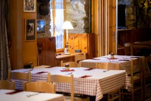 a dining room with two tables and chairs and a window at Aiguille de La Tza in Arolla