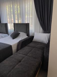 a bedroom with two beds and a couch in front of a window at Moni Homes in Fethiye