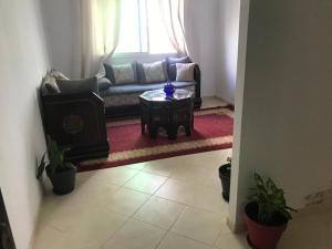 a living room with a couch and a coffee table at Appartement Familial Proche Aeroport Bab Andalous Tanger in Tangier