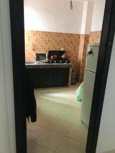 a kitchen with a stove and a refrigerator at Appartement Familial Proche Aeroport Bab Andalous Tanger in Tangier