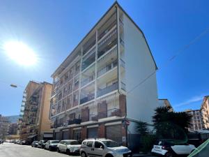 wysoki budynek z samochodami zaparkowanymi przed nim w obiekcie Stella house w mieście La Spezia