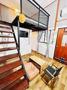 a tiny house with a loft bed and a desk at Ardour Lodge "A" Wing in Tanjung Bungah