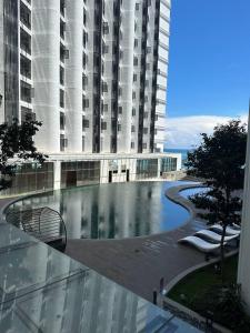 un grand bâtiment avec une piscine en face d'un bâtiment dans l'établissement KK CITY CENTRE 800mbps Unifi,Cuckoo INFINITY POOL STUDIO ROOM, à Kota Kinabalu