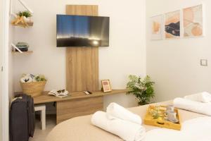 a living room with a desk and a tv on the wall at TwinSuites Malaga in Málaga