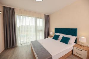 Un dormitorio con una cama grande y una ventana grande. en Lux Apartments Kranevo, en Kranevo
