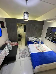 um quarto com 2 camas e um lustre em Green Residences Staycation by PBYY with Complimentary breakfast for 2 em Manila
