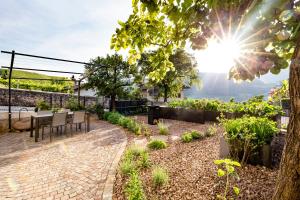 a patio with a table and chairs and the sun at Appartement Irene in Caldaro