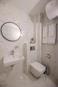 a white bathroom with a sink and a toilet at Lux Apartments Kranevo in Kranevo