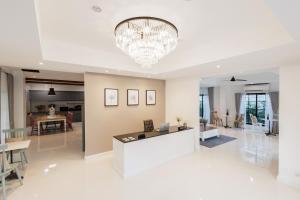 a large white living room with a chandelier at Casa Luna in Bangkok