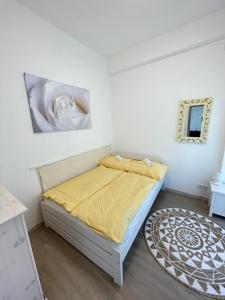 a small bedroom with a bed with a yellow blanket at Gyöngybagoly Apartman in Balatonberény