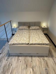 um quarto com 2 camas e pisos em madeira em Domek Apartamenty Sun House em Boszkowo-Letnisko