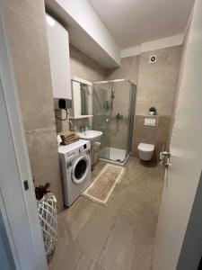 a bathroom with a shower and a washing machine at Apartmani Kastel in Banja Luka +14 photos