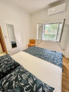1 dormitorio con 2 camas y ventana en Vacation House Lavanda NEW! Heated pool, en Zadvarje
